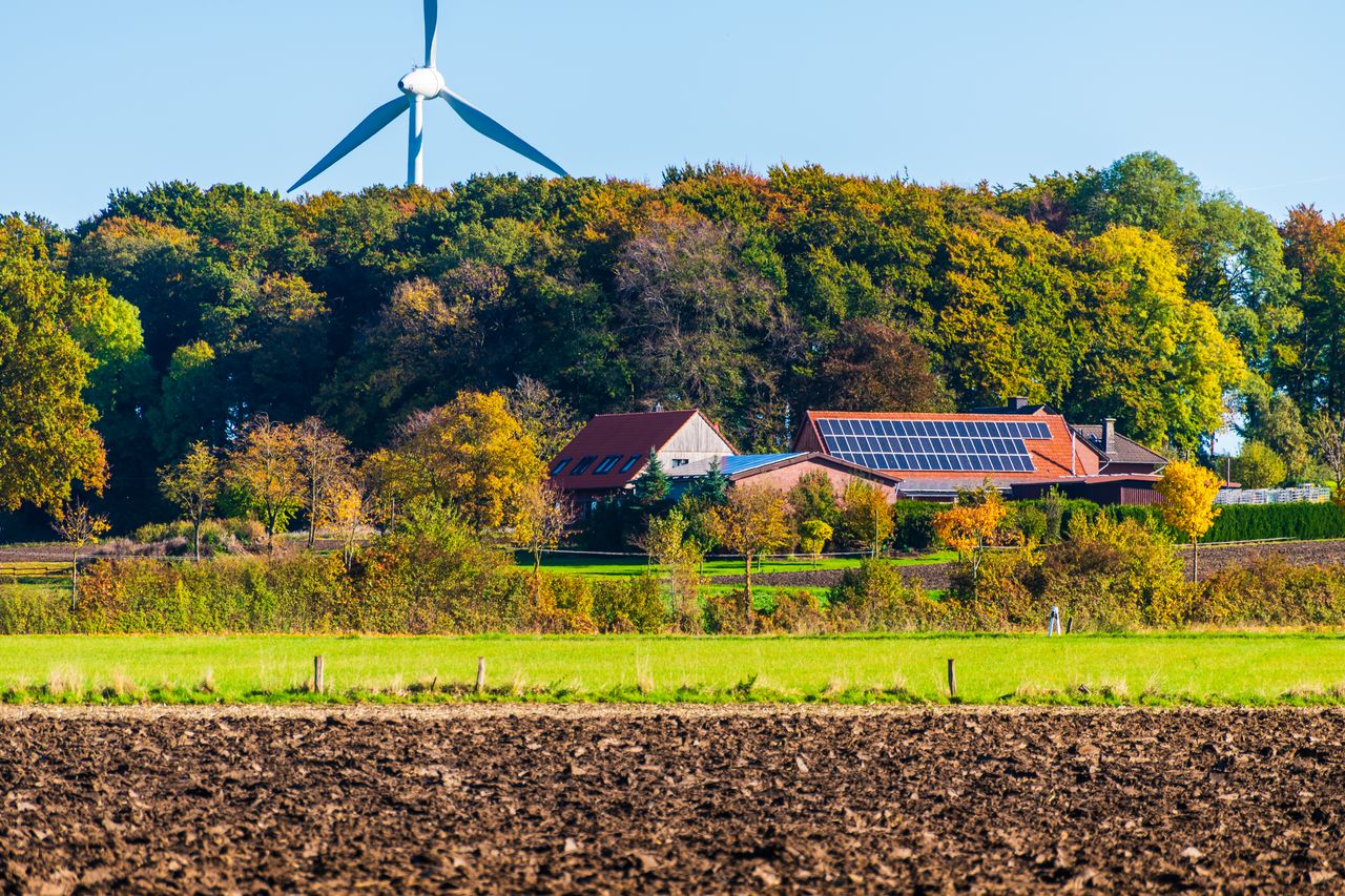 Mastering the First Impression: Your intriguing post title goes here A picturesque sustainable farm featuring wind turbine and solar panels surrounded by vibrant autumn foliage.